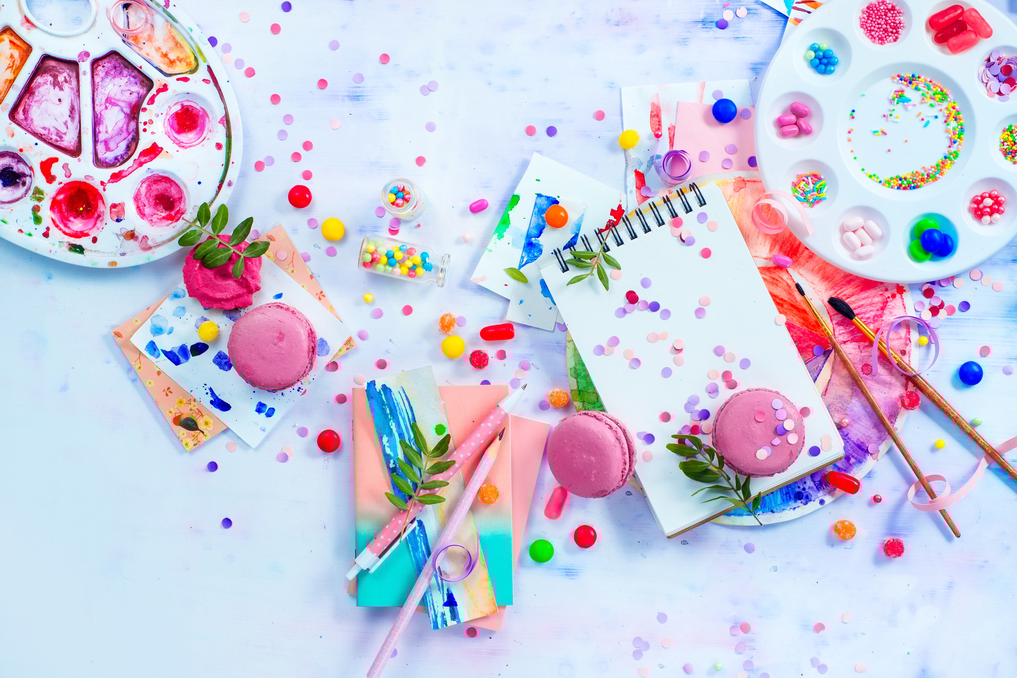 Sweettooth artist tools creative party concept. Pink macarons in a colorful party activity concept